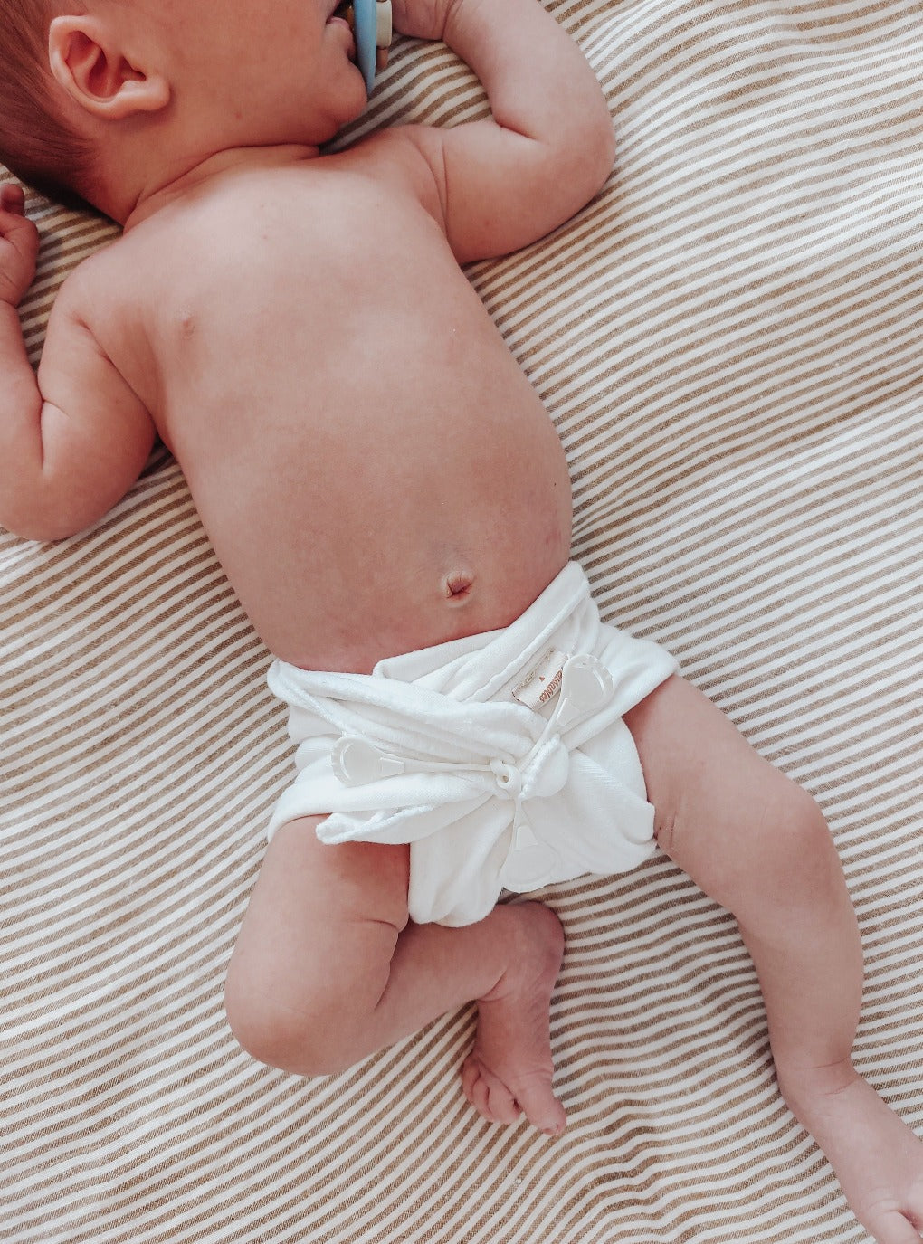 Newborn in a flat style cloth diaper